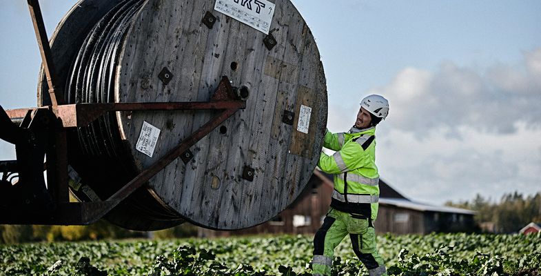 Cable worker pulling medium voltage cable from a drum